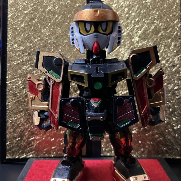 ガンダムマーカー塗装で、一通り完成しています。首と腰が細すぎなので、横にパーツを貼って幅増ししています。肩と胴体の接続部も細い印象でしたので、プラパイプで太く。首はかなり上を向けます。蛇腹状の武者の鎧を模しています。背骨状のパーツも付けています。足底の肉抜きにはG30ガンダムの足底を貼っています。軽装の頭部はSDWHのBUGの頭部を移植してます。元の武者頑駄無リスペクトで、金色の鉢金を付けているようにしています。兜との接続を検討中です。ネオジム埋め込むか？前垂れには隠れ砲を仕込んでます。瓢箪ファンネルも作成予定。パケ絵とは緑が足りませんが、ちょっと余計かなあと、塗ってません。背景にあるのは、やっと見つけたセリアの金屏風。もう1つ欲しい。（7枚目）