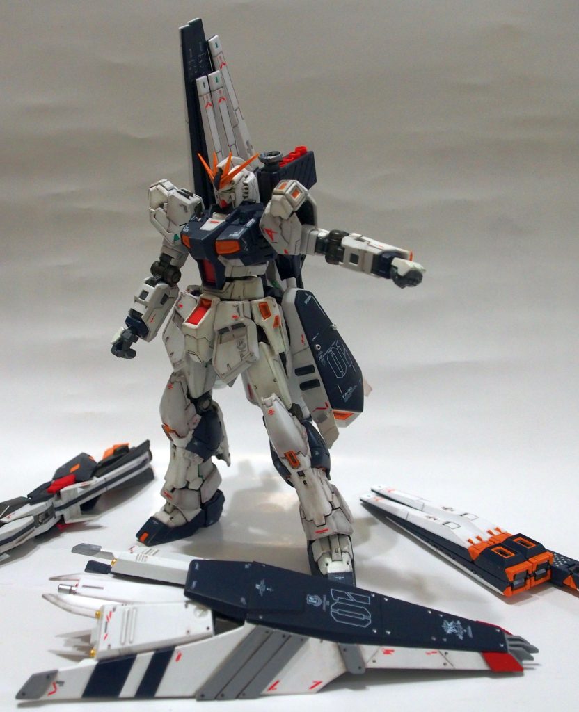 今回の追加兵装がわかりやすいよう、パージした状態です。大型シールドについて、HWSから剥ぎ取った武装はHGのものなので、プラバンとスジボリにてRGの本体となじむようディテール追加。さらに、HWSの腰前部フロントアーマー部分を転用し、縦の上部隙間を埋めるように配置しました。殴り合いにも使えるよう、盾の先端に衝角を装備。盾の上部に追加したバーニアを吹かしながらえぐり込む、といった格闘もこなせるという脳内設定。