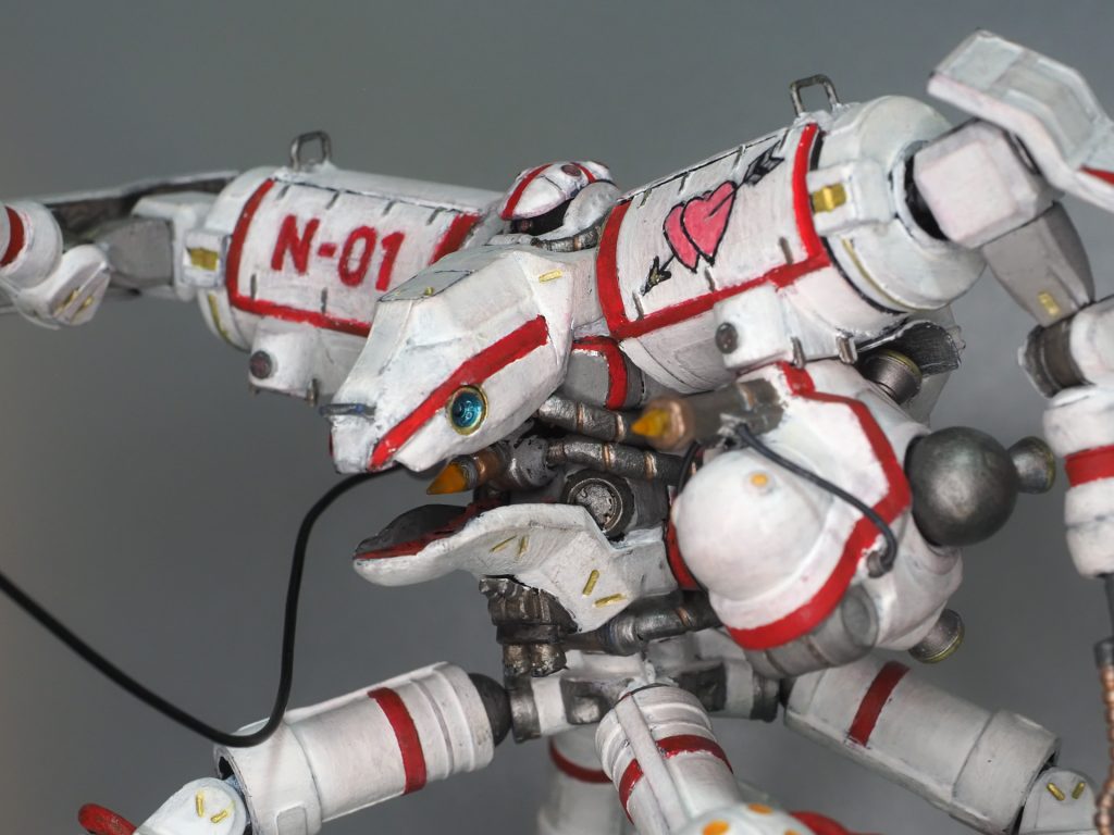 頭部とビット懸吊部の追加カメラは、余りランナーの断面を凹面に彫り込んでメタリックカラーのパステルをテレピン油で溶いたものを塗り、アロンアルファ光を盛って硬化後に磨いて作っています。某MAを思わせる「胸の顔」はGQザクの脛当てとGQゲルググの脛当てを無理矢理くっつけてパテやプラ材で整形しています。