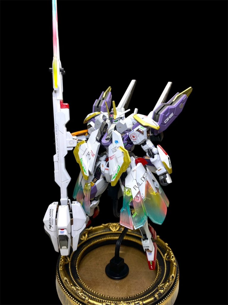 フルドレス装備に、ビットオンフォームで、長物を立てて構えて。ウーンドウォートの設定画にも近くて、お気に入りのポーズです。ビットオンフォームさせると、肩幅などが一気にがっしりとして、見栄えがします。フルドレスの下部分は元々透明のクリアパーツだったので、スコア∞状態のシェルユニットををイメージして、蛍光色でレインボーグラデ塗装しました。ヴァリアブルロッドライフル・セカンドのビームブレードパーツも、クリアパープルと、透明クリアの二種あったので、同じくレインボーグラデ塗装を施しました。