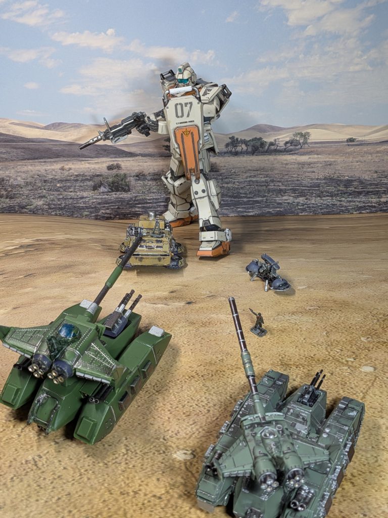 アピールショット２枚目を上から撮った図ちょっと縦にぼかしを入れて、ミサイルや爆発や煙のエフェクトを貼る加工をしましたホバートラックの上に連邦兵が乗っているのがポイント