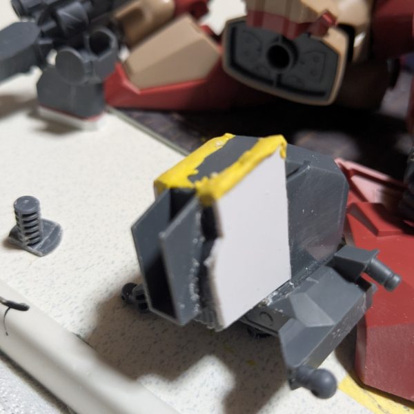 太ももを切ってプラ板を挟んで、削るのが面倒くさいから簡単に脚を延長出来ないなぁ〜？と行き着いたのが、股軸を下げるだった。D2の39番とＤ2の32番の股軸を画像の様に、約1.5ミリ幅詰め左右合わせて約3ミリ幅詰めした。空いた穴をマスキングテープで、形を取り、それを1ミリのプラ板で形を作って穴を塞ぐ。隙間をポリパテで埋めた。股を左右合わせて、約8ミリ以上幅詰めをした。後、足首を延長した事で見た目も良くなったかなぁ〜？（5枚目）