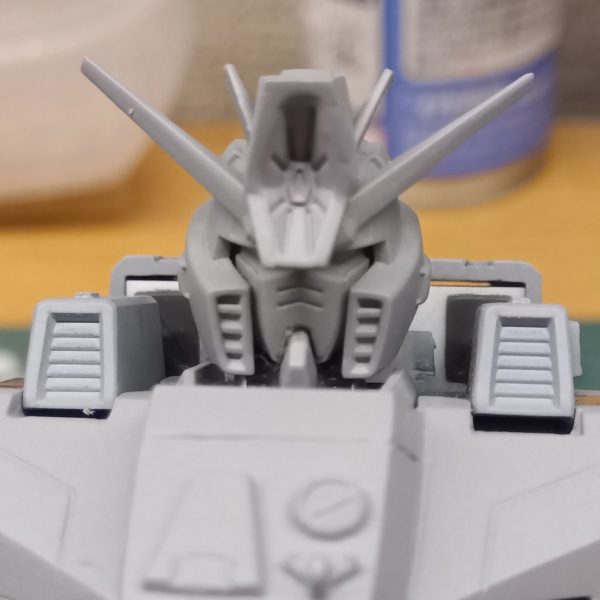 着々と作業も進み、サフ吹きまで進むパーツもチラホラ(私は一気にサフ吹き、本塗装するタイプではなく、表面処理の終わったものからちょこちょこ塗っていくタイプです)頭頂部のハイメガキャノンのトコにキズがあるからもう一度表面処理しなきゃないなーと考えていたとこなのですが………頭頂部のハイメガキャノンってエネルギー供給とかどーなってんのかなって思ったりしません?多分胴体部でエネルギーを生成(?)するのでしょうけど、そのエネルギーを首の部分を通って頭頂部のトサカまで行くってどうなってるのかなって考えちゃいますよね(笑)でも映像としては頭頂部からビームが出るのはカッコいいんですよね👍️さて、そろそろ何色に塗るのか検討中でございます陸戦型なので戦車っぽいカラーリングにしたいですが、戦車は詳しくないのでネット検索して勉強しなければ🤔ハイメガキャノンはプラ板で幅増しして大型化して取り付け部で下に下がるように加工してありますまた目つきが悪くなるようにフェイスとヘルメットの接合部で削ってヘルメットが下に下がったように加工してあります(2枚目)