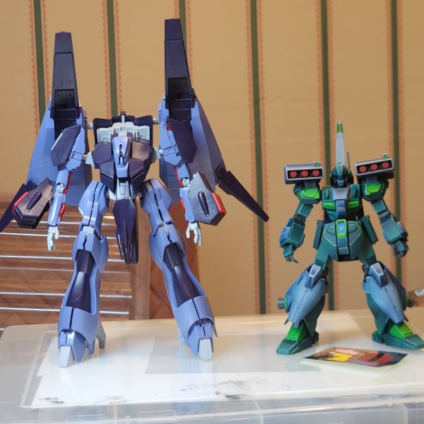 新しいプロジェクトが進行中です。PMX-000 メッサラです。おそらく私が作ったHGの中で最大の機体です。ジェガンと並べて見てください。今回も「クリムゾンムーン」という塗料セットを購入し、その色を取り入れたいと思いました。赤と紫です。参考のために色のモックアップを作成しました。赤い部分はすべて完成し、エッジハイライトも済ませました。しかし、腰が痛くなったので、今は作業を中断せざるを得ませんでした。ああ、私も年を取ったものです。-A new project is underway. It is the PMX-000 Messala. The unit is possibly the largest HG I have made. Take a look at it side-by-side with the Jegan. Again, I purchased a set of paints called 'Crimson Moon' and wanted to incorporate those colours. Reds and purples. I created a colour mock-up for guidance. All the red parts are completed &nbsp;and edge highlighted. I had to stop for now though because my back was aching. Gosh, im getting old.（7枚目）