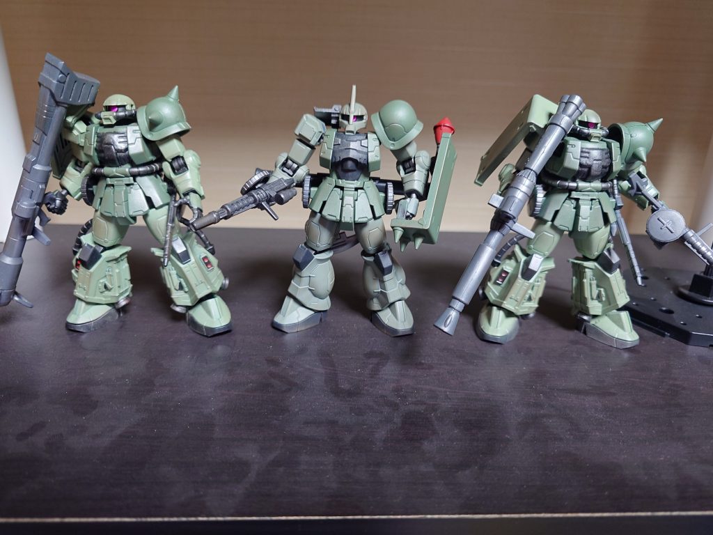 旧ザクと小隊結成。旧ザク隊長に06R隊員。ずいぶんアンバランスで贅沢な編成です。左肩アーマーの緑が濃いのはジオン兵の間で緑の烈風のシンパの印みたいなもので、誰ともなく始めた、という設定です。緑の烈風はその狂犬のごとき戦いぶりでMSパイロットからは嫌われているものの、防衛任務の成功率は群を抜いて高く、それによって家族や友人が助かった者もいるため、少数派ながらもシンパはいるということで。ソロモン防衛隊のイメージで、各々ともありったけの武装を積んであります。また、最近のキットは予備弾倉も普通にありますが、昔の劇中では予備弾倉どころかリロードの描写もないんですよね。マシンガンはともかくバズーカはいくらも装弾数ないんだから、MSの継戦能力にはちょっと疑問があります。なので、自分としては、戦場の所々に補給ポイントとして、武器や応急修理ツールを積んだコンテナみたいなのを艦船から射出しているんじゃないかと解釈しています。なお、巷ではザクⅠと呼ばれるようになって久しい旧ザクですが、自分はあくまで旧呼称で呼びます。HGやGフレームで今風にリファインされても色褪せぬこの野暮みには、旧の呼び名こそ相応しいです。しかし、旧ザクをここまでスタイリッシュにアレンジするGフレームのデザイナーの腕前は素晴らしいです。これまではザクやゲルググを作るときは角つきばかり作ってきたので、たまには角なしも新鮮に感じます。ご覧いただきありがとうございます。