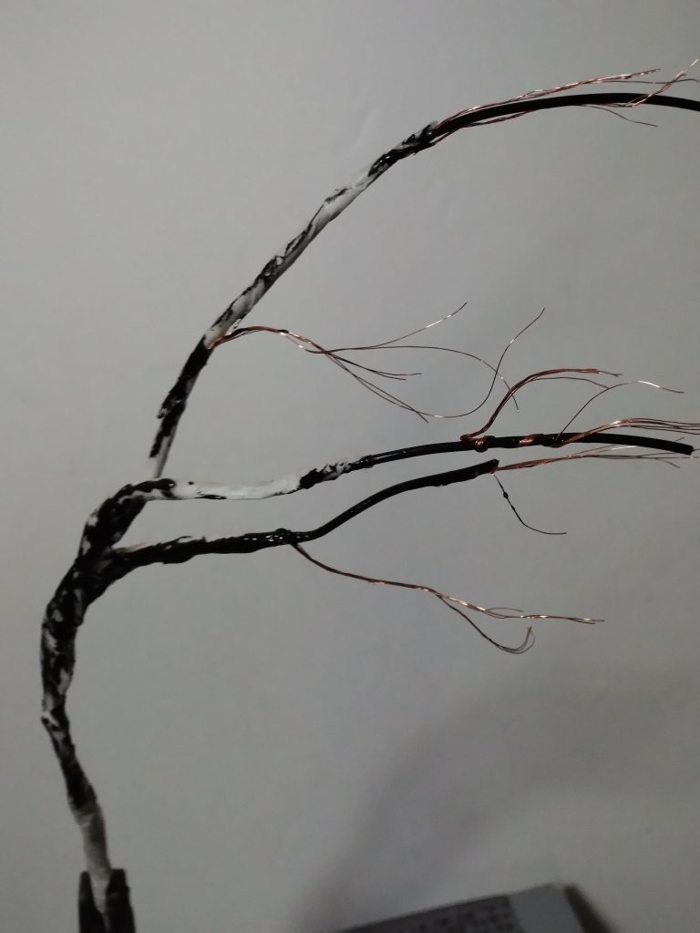 太い枝や幹の部分はマスキングテープの巻き方で太さ変化させました。これを塗装してから枝に瞬間接着剤塗ってピンクの削ったスポンジを接着してます。ベースは100均フォトフレームにホームセンターのコンクリート補修材を塗って地面作りしました。初めはグレーで塗装しましたがリアル感あってやり直し。適当な波模様を描くことにしました。