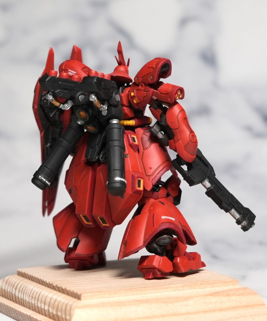 ガンダムアーティファクトのプラ表面は粒子のようなザラザラしているので、全体を1000番くらいのヤスリがけを行い撮影してアップにしても目立ちにくいように気をつけました。赤色の基本色はエアブラシでクレオスのキャラクターレッドを使用。それにマルーンを混ぜた色の２色で塗り分けています。スラスターという呼び名で良いかわかりませんが中の黒い部分はマスキングテープを黒に塗装したものをカットして貼り付けています。モールドは太めなので、黒色で墨入れはせずにブラウンで行いました。仕上げに全体を艶消ししています。