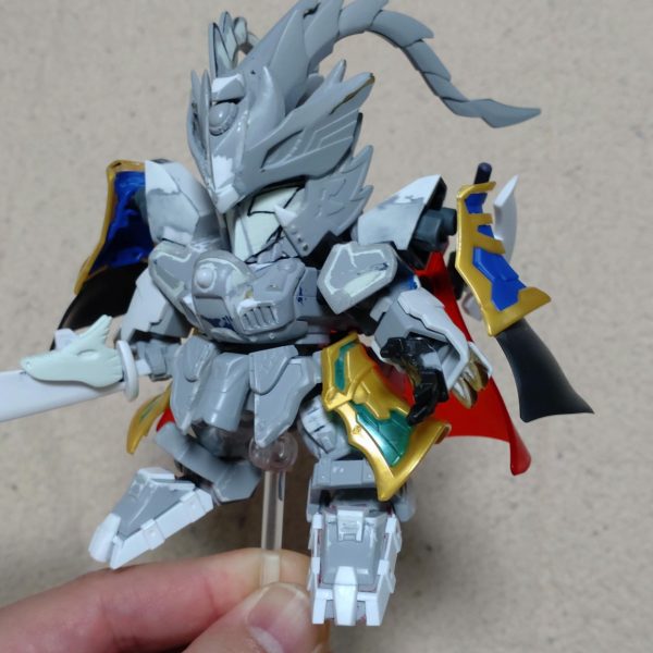 はじめまして、ノンマルトのシ者と申します。プラモデルの改造は初めてですが、色んな方の改造例を参考にひとまずここまで形にしました。三国伝の魏延マークIIがパワーアップした姿をマスクコマンダーをイメージして制作。基本的にはLGBB武者飛駆鳥と黄忠ガンダムを使用。その他装備にはエクスヴァルキランダーや玄武装呂布トールギス、直江兼続頑駄無、三国創傑伝キット等のパーツを流用。流用出来ない部分はプラ板やランナー、パテで自作し、市販のジョイントや関節パーツで形にしています。仮面は黄忠ガンダムの眼帯を改造し取り外し可能です。各種武器は合体させて巨大な武器にも。バックパックは鎧や武器と合体して、マスクコマンダーのICBMハンブラビをイメージした鳥っぽい支援メカに。まだモールドを入れたり修正もして…色も決めなきゃ…^^;（2枚目）