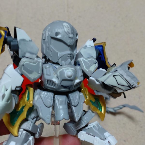はじめまして、ノンマルトのシ者と申します。プラモデルの改造は初めてですが、色んな方の改造例を参考にひとまずここまで形にしました。三国伝の魏延マークIIがパワーアップした姿をマスクコマンダーをイメージして制作。基本的にはLGBB武者飛駆鳥と黄忠ガンダムを使用。その他装備にはエクスヴァルキランダーや玄武装呂布トールギス、直江兼続頑駄無、三国創傑伝キット等のパーツを流用。流用出来ない部分はプラ板やランナー、パテで自作し、市販のジョイントや関節パーツで形にしています。仮面は黄忠ガンダムの眼帯を改造し取り外し可能です。各種武器は合体させて巨大な武器にも。バックパックは鎧や武器と合体して、マスクコマンダーのICBMハンブラビをイメージした鳥っぽい支援メカに。まだモールドを入れたり修正もして…色も決めなきゃ…^^;（4枚目）