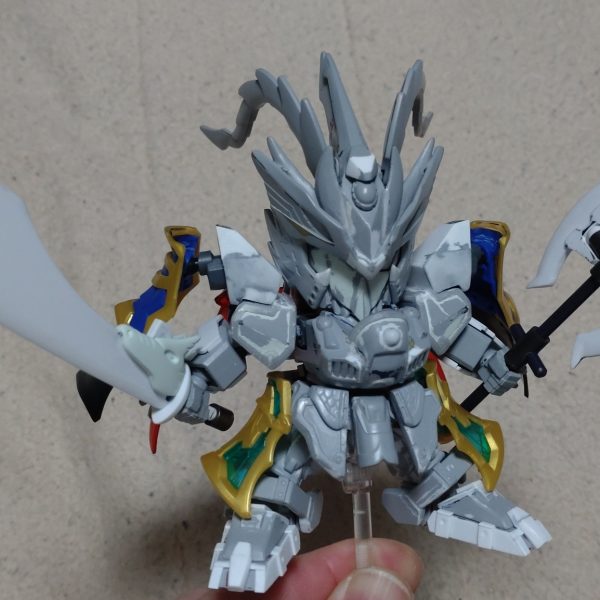 はじめまして、ノンマルトのシ者と申します。プラモデルの改造は初めてですが、色んな方の改造例を参考にひとまずここまで形にしました。三国伝の魏延マークIIがパワーアップした姿をマスクコマンダーをイメージして制作。基本的にはLGBB武者飛駆鳥と黄忠ガンダムを使用。その他装備にはエクスヴァルキランダーや玄武装呂布トールギス、直江兼続頑駄無、三国創傑伝キット等のパーツを流用。流用出来ない部分はプラ板やランナー、パテで自作し、市販のジョイントや関節パーツで形にしています。仮面は黄忠ガンダムの眼帯を改造し取り外し可能です。各種武器は合体させて巨大な武器にも。バックパックは鎧や武器と合体して、マスクコマンダーのICBMハンブラビをイメージした鳥っぽい支援メカに。まだモールドを入れたり修正もして…色も決めなきゃ…^^;（6枚目）
