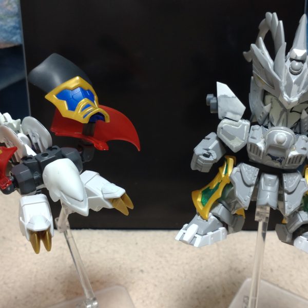 はじめまして、ノンマルトのシ者と申します。プラモデルの改造は初めてですが、色んな方の改造例を参考にひとまずここまで形にしました。三国伝の魏延マークIIがパワーアップした姿をマスクコマンダーをイメージして制作。基本的にはLGBB武者飛駆鳥と黄忠ガンダムを使用。その他装備にはエクスヴァルキランダーや玄武装呂布トールギス、直江兼続頑駄無、三国創傑伝キット等のパーツを流用。流用出来ない部分はプラ板やランナー、パテで自作し、市販のジョイントや関節パーツで形にしています。仮面は黄忠ガンダムの眼帯を改造し取り外し可能です。各種武器は合体させて巨大な武器にも。バックパックは鎧や武器と合体して、マスクコマンダーのICBMハンブラビをイメージした鳥っぽい支援メカに。まだモールドを入れたり修正もして…色も決めなきゃ…^^;（7枚目）