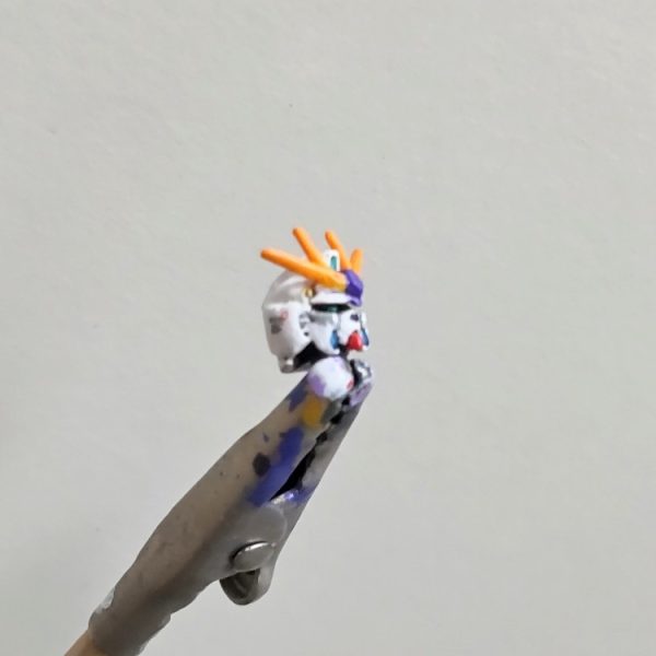 いつもとは違いますが、頭部作成しました😄。いつもは頭部が最後なのですが、「頭部って、どうやって塗ったらエエんやろう❓️」の疑問からやってみたくなったので手を付けました。正直、この小ささエグいです、これ以上は無理です、そして白は苦手です😓。一応、頭部センサーとツインアイはメタリックグリーン(写真では見えませんが)、バルカンはゴールド、アンテナはオレンジと少しのイエローで調色、アンテナの基部はパープル、頬はディテールがあったのでシルバーとブルーメタリック、顎はレッドで塗ってみました。スミイレはくどくなりそうなので軽め、というか筆ムラで汚くなりそうなので軽めにしました😅。アラ隠しにデカールも貼ってみました。2度とやりたくない😓（1枚目）