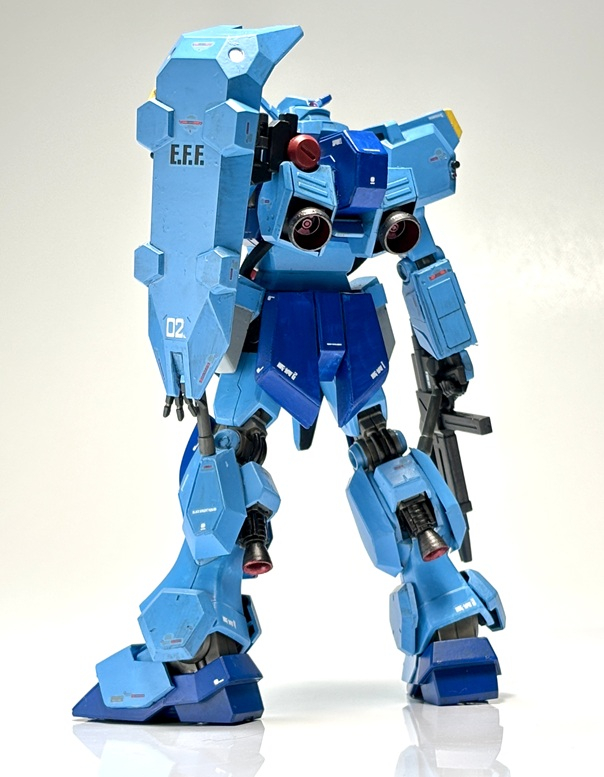 リアアーマーはプラ板でスムージング。グスタフ・カールの脚の下部のフィンパーツを、ふくらはぎに装着して、プラ板で加工。ビームサーベルを装着。背面も小加工で形状変更。グスタフ・カールの肩アーマーの増強パーツ(?)を、くるぶし近辺に装着。スリッパまわりもプラ板加工。こういった加工、造形変更で、νガンダムっぽさは薄れたと思います。