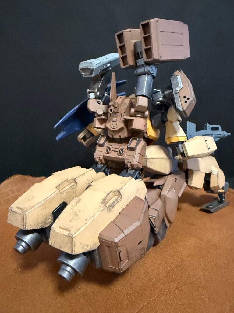 　高性能な火器管制システムと武装追加の為の武器プラットフォームで構成されたバックパックを追加されたことにより、支援機としてより幅広い運用が可能となった。本来、バックパックはバーザムと同等の物の為、支援機としての火器類は肩アーマー部の武器プラットフォームに搭載される物だけだった。しかし、バックパックにも武装を搭載することが可能となった為、本来想定された仕様より重武装が可能となったのは、不幸中の幸いと言っても良いだろう。　そして、より重武装化した上半身を支えるのが、脚部内、腰後部から伸びる二対のユニット内の高性能なホバークラフトユニットである。MS、人型の時点で高いホバー性能を持つが、脚部前面の装甲ユニットを展開し、脚部自体を簡易的に畳み、ホバークラフトモードと言う形態を取る事で、より高いホバー機動が可能となっている。　厚い装甲に覆われた、腰後部から伸びるホバーユニット。このユニットの脇に見えるボックス（濃い茶色の部分）内には、主にマシンガンの予備マガジン、小型ミサイルなどの予備弾薬が内蔵される。しかし、再装填の際は、単機では出来ず、二機以上での運用が想定されている。また、ホバークラフトモード時限定ではあるが、左右それぞれに十人程ではあるものの兵員の輸送も可能となっている。…乗りたがる兵はいないのだが。