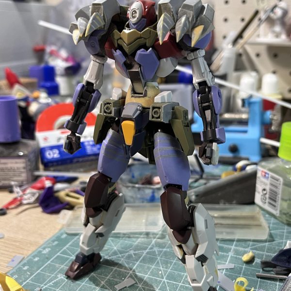 ちょっと間が開きまして…久しぶりの投稿になります。というのも最近仕事が忙しすぎて全然時間が無いのです😭それなのに来月の静岡ホビーショーまでに間に合わせなきゃならないという鬼畜スケジュールで🙃まあそんなことは置いといて現状報告です。一番苦戦するだろうと思った肩周りのパーツ。これは画像のようにジンクスVIの肩をベースにプラ板でカーブの骨組みを4つ作りつつプラ板とパテで整形。接続はボールジョイントにすることで可動域を確保しています。更に幅詰めでシルエットを調節。爪はプラ板をベースにパテで整形しました。足回りはそのままだと上半身と比べて細身になってしまうのでムーンガンダムのパーツでボリュームを持たせました。顔はジークルーネのパーツで仮面っぽくしてあります。角は後で作るということで…最後に元にしたゴアマガラ装備の画像を置いておきました。どうでしょう、寄せれてますかね？（6枚目）
