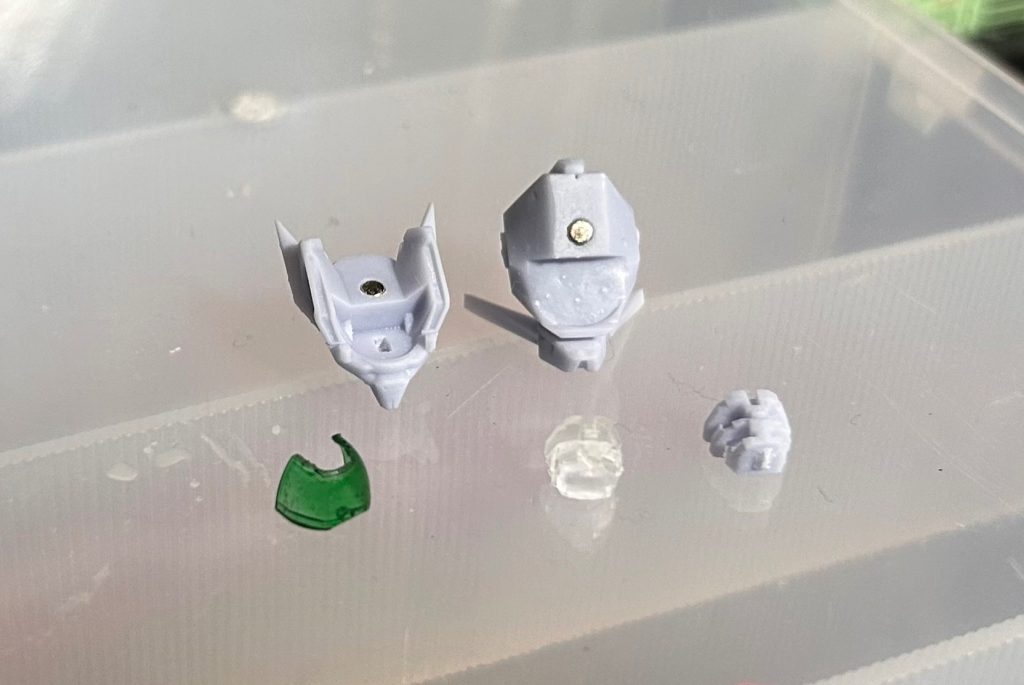 今回はレジンを使用する光造形プリンターなので0.02mmまで造形可能！キケロガ作成時はFDMだったので、細かな造形は諦めて手作業だったのから感動🥹頭部を上下で分割してネオジウム磁石で接続する方式にしましたが、この分割だと頭動かすたびに頭が夏油しちゃうので次回同様の加工をするときはもう一工夫するつもり🤯レジンはクリアパーツも自作が容易なので、バイザーとモノアイパーツもご覧の通り破損バイザーはノーマルバイザーをニッパーで刻めばええかと横着したら一刀目で真っ二つに割れたので、素直にデータを作成しました😆