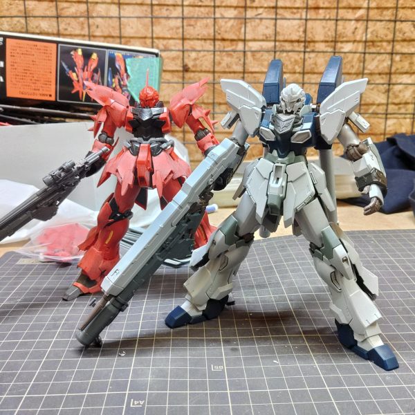 シナンジュを製作していたところ、シナンジュ・スタインの再版がちょうどよくかかったので、シナンジュと並べようと入手しました。パッケージの完成写真を見るに、そのまま作るだけでかっこ良さそうなので早速着手しました。面の整形のみで完成させようと思ったのですが、シナンジュと並べるとバックパックのボリュームが少し寂しい気がしました。ゾルタン機としてノーマルスタインとの差別化をはかるべく、ランナータグでバックパックを延長しつつ、立ちポーズに少し修正を入れていきます。（2枚目）