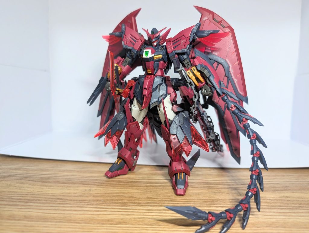 エピオンゼピュロスRGガンダムエピオンにパーツを追加して部分塗装と付属デカールとつや消し。大きくイメージは変えずに、追加パーツを本体に合わせる形で色合いを整えた。顔は赤いバイザーを追加。中から緑のカメラアイが見えるイメージ赤いバイザーやメインウイングの光の翼は赤クリア下敷きを切って製作。塗装も含めて雑なので細かくは見ちゃ困ります。追加武装は基本的に近接武器で、エピオン本来のイメージを守るようにしている。変形の邪魔にならないように配慮して追加武装を付けている。武装制御に機体システムのメモリを使わせることでゼロシステムに負荷をかけ、過剰な未来予測による暴走を防いでいる。