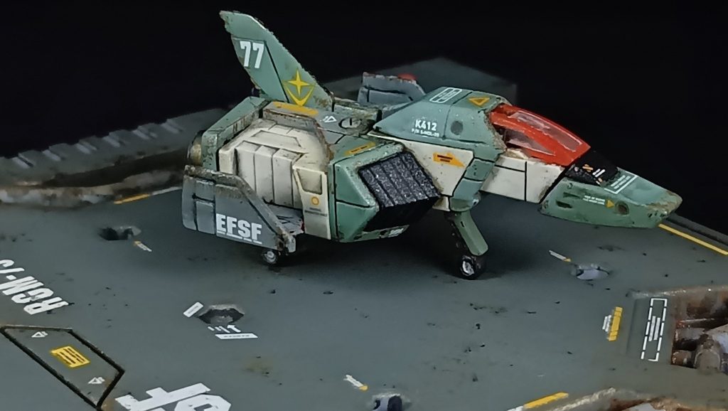 スレッガーRGM-79のイメージでコア・ファイターを塗装してみました。メインカラーのライトグリーンにグリーンを混ぜ、翼はライトグリーン。ダクトは通常のブラックに、白い箇所は前回RGのガンダム使用したガルグレーとホワイトを混ぜたものを使用しました。グリーン系のワンポイントしてキャノピーのフチドリを赤みが強いオレンジで強調させました。(zaku-kao4)デカールもオレンジ系を意識して貼りました。
