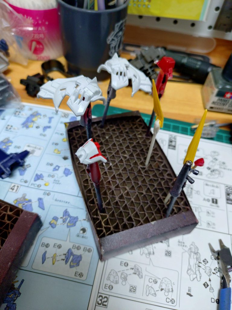 カラー外装を参考に部分塗装①最近作ったバンシィの説明書を机に広げたまま…余りパーツで盾作れると思ってランナーもまだ片付けてない状態です。