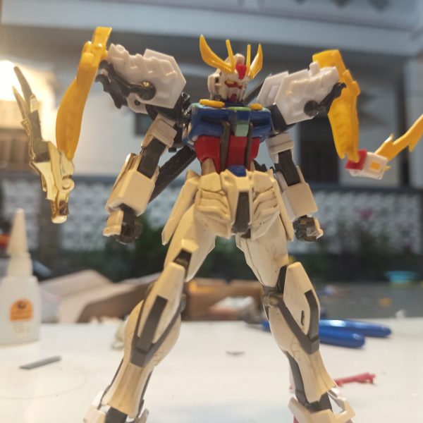HG 1/144 Strike RyubiThis custom project started from my interest in the SD Ryubi from the SD Brave Battle Warriors line. What attracted me the most was the unique “3 Beast” feature, which works similarly to the striker pack system from the Strike Gundam in Mobile Suit Gundam SEED.However, over time I felt the original SD proportions did not fully match the image I had in mind. The oversized chibi-style head reduced the majestic and warrior-like presence I wanted the design to have. Because of that, I decided to combine it with the body of the Entry Grade 1/144 Strike Gundam to achieve a more balanced proportion.As the project evolved, I continued rebuilding and refining the design. I felt the overall shape still lacked a noble and powerful appearance, and the body’s imaginary lines looked too thin and less imposing. So I decided to do another round of kitbashing using parts from the SD World SDSS Zhang Fei God Gundam from the Sangoku Soketsuden series.I used the waist armor parts to create a more majestic silhouette inspired by traditional Japanese samurai armor. I was also fascinated by Zhang Fei’s claw-like facial ornament, so I adapted those elements into claw details and blade features. The blade parts originally attached to Zhang Fei’s arms were then relocated onto the legs to strengthen the aggressive and heroic feel of the final design.Although this project is still unfinished and continues to evolve, I’m happy because little by little the design is starting to get closer to the image I imagined in my mind. Hehe.(6枚目)