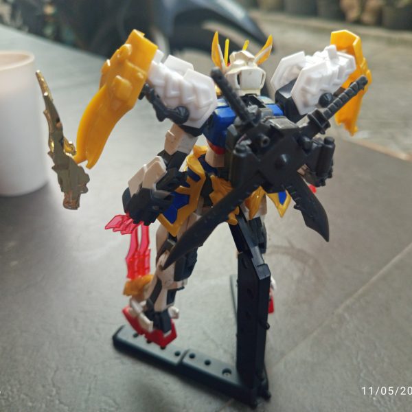 HG 1/144 Strike RyubiThis custom project started from my interest in the SD Ryubi from the SD Brave Battle Warriors line. What attracted me the most was the unique “3 Beast” feature, which works similarly to the striker pack system from the Strike Gundam in Mobile Suit Gundam SEED.However, over time I felt the original SD proportions did not fully match the image I had in mind. The oversized chibi-style head reduced the majestic and warrior-like presence I wanted the design to have. Because of that, I decided to combine it with the body of the Entry Grade 1/144 Strike Gundam to achieve a more balanced proportion.As the project evolved, I continued rebuilding and refining the design. I felt the overall shape still lacked a noble and powerful appearance, and the body’s imaginary lines looked too thin and less imposing. So I decided to do another round of kitbashing using parts from the SD World SDSS Zhang Fei God Gundam from the Sangoku Soketsuden series.I used the waist armor parts to create a more majestic silhouette inspired by traditional Japanese samurai armor. I was also fascinated by Zhang Fei’s claw-like facial ornament, so I adapted those elements into claw details and blade features. The blade parts originally attached to Zhang Fei’s arms were then relocated onto the legs to strengthen the aggressive and heroic feel of the final design.Although this project is still unfinished and continues to evolve, I’m happy because little by little the design is starting to get closer to the image I imagined in my mind. Hehe.(2枚目)