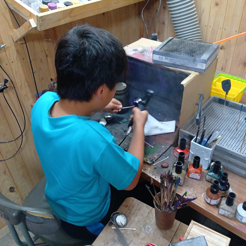 作業中。胸の黄色以外は全部エアブラシ塗装です。まだパーツとエアブラシの距離を取りにくいみたいで、何度か塗りなおししてました。