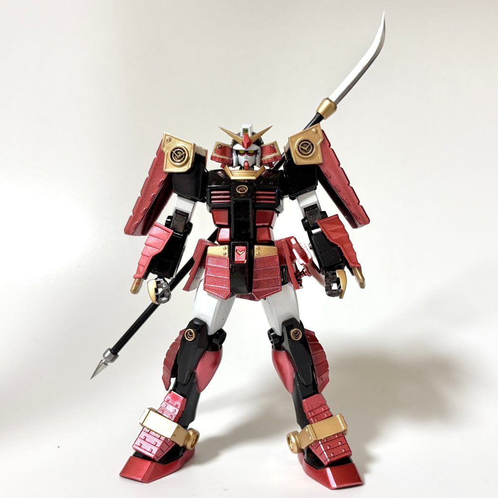 そして完成したのがこちら。いかがでしょうか。BB戦士やモビルスーツ戦国伝、MG、ROBOT魂など時代の流れの中でどんどんブラッシュアップされてきた武者ガンダム。それゆえ、昨今では複雑なデザインが取り入れられたりもしていますが、今回目指したのは、「古き良きオーソドックスな武者ガンダム」です。あまり奇抜なデザインにならないように、それでいてのっぺりしない程度のデザインを心がけました。カラーリングは高級感を出したかったので、光沢&メタリック調で進めました。赤い部分は「Mr.メタリックカラー：GXメタルレッド」です。