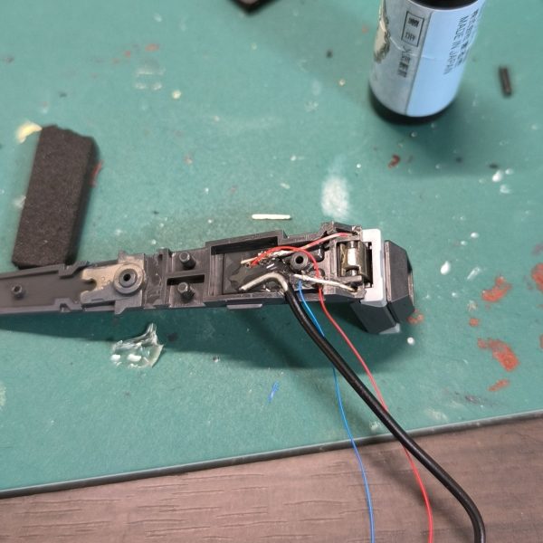 制作過程のほうを投稿するのはあんまりないですが、今回はえらい苦労たので参考までに…。ガンプラの電飾は、それこそ学生時代にムギ球（若い人は知らないだろうな）を入れ込んだ以来なので、まずLEDの小ささに感動です。この大きさでなんでこんな明るいの…。ガンプラを固定モデルとして組むなら、ある程度割り切って配線して行けたのですが、今回は可動域も確保したい＆メンテナンスとしてばらすことも考慮したい、ということで、USB-Cケーブル分解して接点出したり、屈伸時に電線の遊び部分確保に苦慮したりと、非常に苦労しました。胸部の配線とか、かなり絶望的でした…。廃棄品のWiFiルータケースを土台にし、そこにギリギリの高さで収まる田宮のギアボックスを装備。もっと小型のサーボモータを在庫で持っていたので、本当はそれを使いたかったのですが、トルクが足りなくてファンネルを持ち上げられないということが発覚。結局、ドライバーを介してギアボックス付きモータを回す、という構成になりました。生まれて初めて田宮の『楽しい工作シリーズ』買った…。電装品としてラズベリーパイ、モータードライバー（赤い基盤のやつ）を何とか押し込み、ワイヤーは空中配線、グルーガンや手持ちのねじでざっくり固定という、電子工作のプロが見たら発狂するような構成です…。（6枚目）