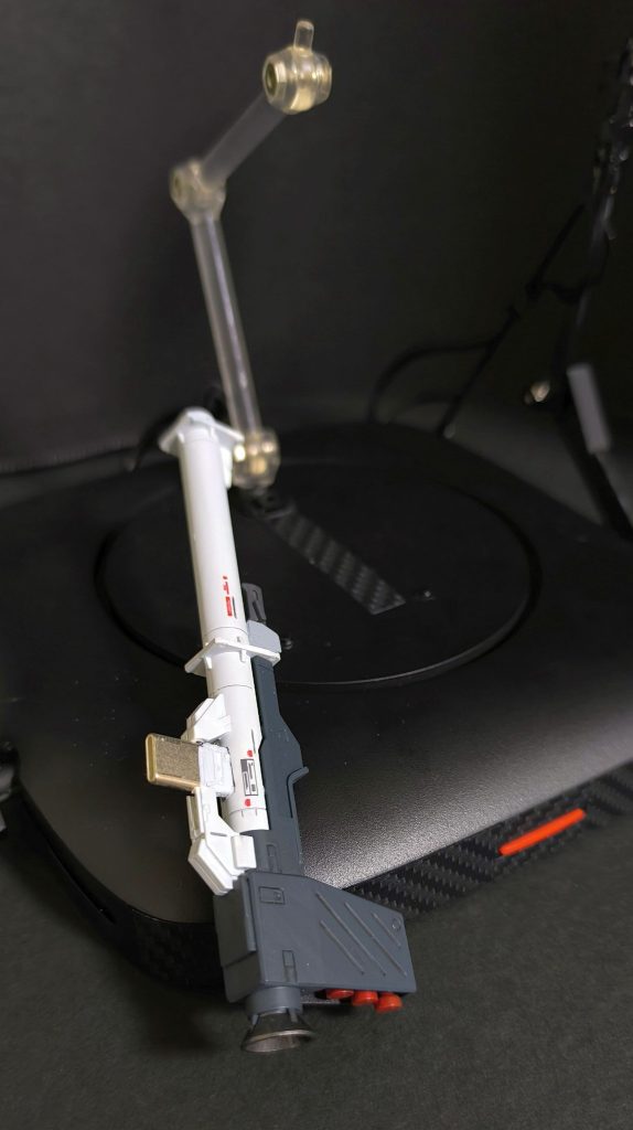 台座は、某バ〇ファローのWiFiルータ廃棄品を転用しています。といっても中の基盤は当然ながら全く使わず、ガワとボタン辺りのみ使っています。ルーターは廃熱用の側面通気口が開いていたので、カーボンシールで目隠ししています。本体LEDへの信号線として、USBケーブルを利用。ラズベリーパイとつないでいます。本体と台座を分離できるようにするためで、USB-Cコネクタをバラし、バズーカに仕込んで接続できるようにしました。