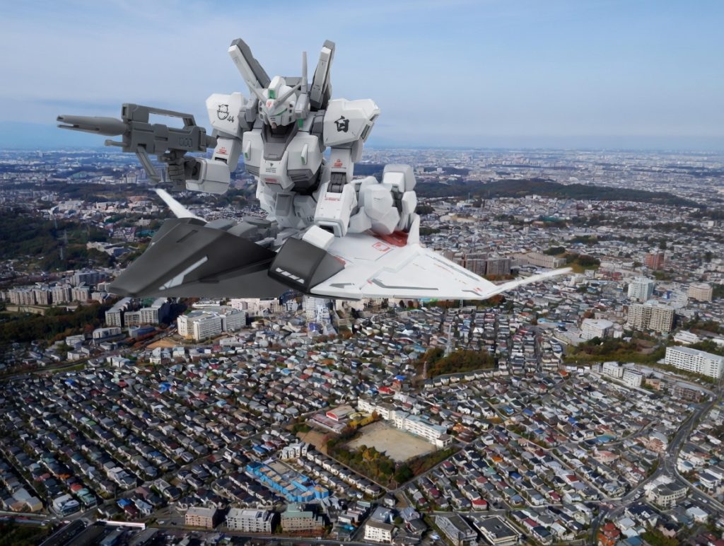 スノーホワイト？でぴよぴよぱっか～んなガンダムＭｋ-II(ガンダムＭｋ-II 川崎純情小町吉川佳那専用機)を乗せて彼女の担当区の一つである麻生区(新百合ヶ丘)上空を飛んでいる写真もGrokを利用して作成してみました。※麻生区上空の写真に関しましては写真素材 フォトライブラリーさんから購入したものを利用しています。