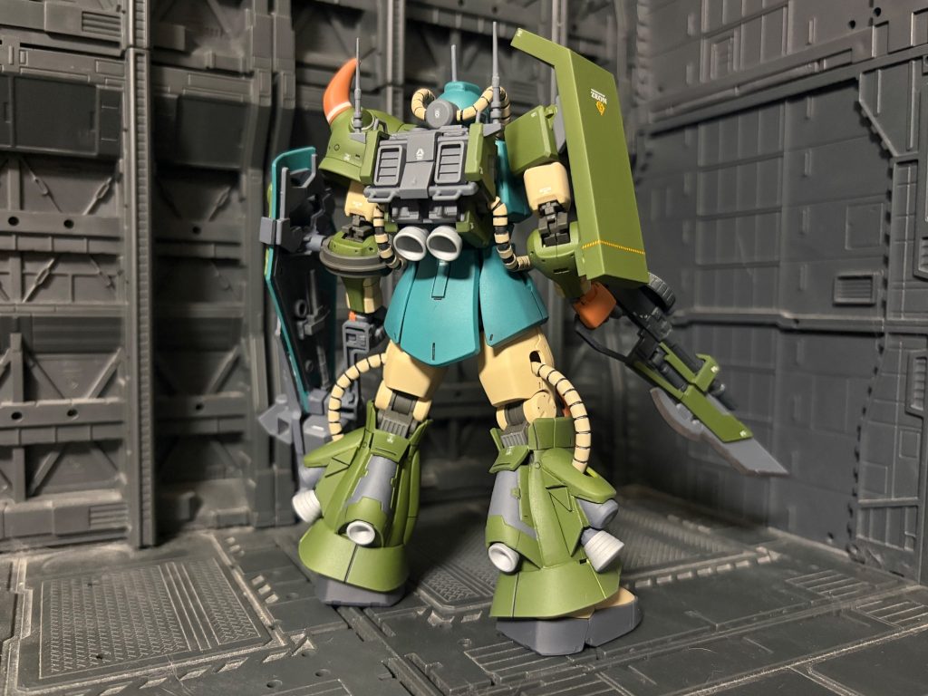 この機体はキャリフォルニアベースに残されていたMS-07BグフとMS-06G陸戦高機動型ザクからかき集めたパーツで組まれた現地改修機である。グフの局地改良、試作機の製作を行っていたキャリフォルニアベースではグフの発展改良型案としてMS-06R高機動型ザクのグフタイプが立案される。このプランはザクの正当な後継戦力として宇宙でも活動可能な機体になると想定されたが、戦況の変化や物資の不足、更にツィマット社によるプロトタイプドムの完成などにより機体需要が見込めずペーパープランとしてお蔵入りとなる。オデッサ作戦において大敗を期したジオン軍は各方面への退却を始める。キャリフォルニアベースは宇宙へ逃げる為の玄関口であり、ジオン軍にとっては要所の一つであった。この拠点をなんとしても防衛するべく、各地から退却してきた戦力をかき集めた。しかし、オデッサ作戦での敗戦もあり余力は残されていなかった。そんな中、戦力増強を本国から強いられたキャリフォルニアベースではペーパプランとして止まっていた高機動型グフを各地からの資材や余剰パーツから今までのノウハウで組み上げた。バックパックの大型化や脚部のスラスター増強に伴う機動力アップやセンサーの索敵能力向上は元のプラン通りだが、本来のプランに足りないグフのパーツもあったことから高機動陸戦型ザクから足りないパーツを流用し組み上げている。また機動力を残しつつ火力増強をする為にシールドのガトリングをグレネードランチャーへ変更、パイロットの近接戦闘においての要望などから銃剣が追加装備された。なおパーソナルカラーで塗装される予定だったが塗料が足りず、手足は余剰塗料で塗り分けられている連邦軍によるキャリフォルニアベース攻略戦において交戦記録が残っているがその後の詳細は不明