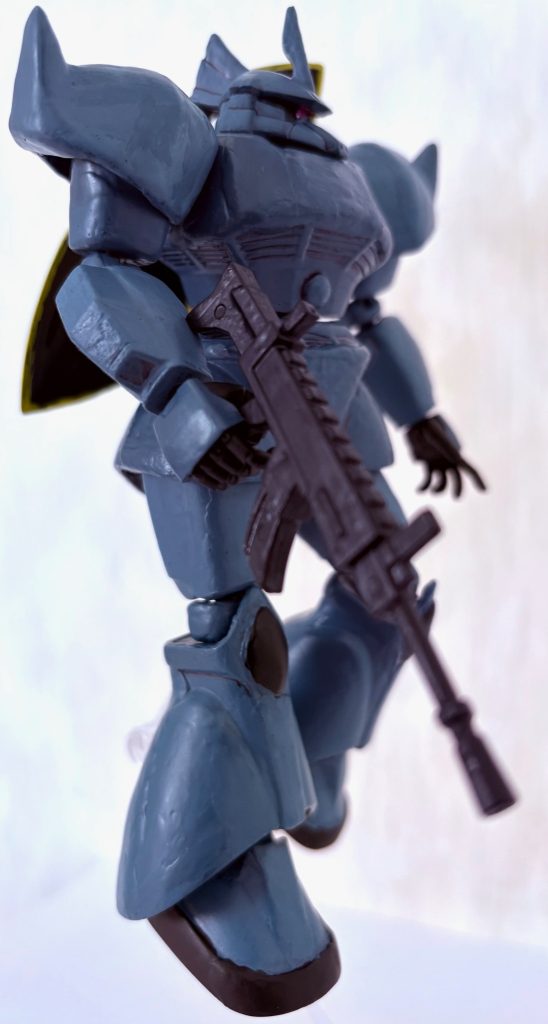 手に持っているライフルは元々セリア（百均）で売っているアクションフィギュア用のモノであり、HGUCや1/144スケールならこのように持たせられる。元の色は青と黒の水鉄砲みたいなチープな色合いだったが、つや消しブラックで塗装したおかげでゲルググにベストマッチな武器になった。