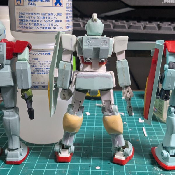 ようやっと全身の加工が完了しました。左右は比較用の加工前旧キットとHGさんです。なかなかによさげになったんじゃないでしょうか？トサカ、胸の排気ダクト、肩パーツ、スリッパ、腰の上半分、腿の前半分は以前ガンダムシュピーゲルを改造したときに関節をもぎりとったEGガンダムの残骸から拝借。拳はたぶんコレクションシリーズのフリーダムのジャンクから。バックパックもEGガンダムのが使えたらよかったんですが、前回の旧キットザクつくったときにバーニア部をもぎって壊しちゃったんで使えませんでした。もったいなかった。盾は磁石接続にしてます。ポリキャップ仕込むとかより工作が楽なので。あと黄色い十字だけなんかで余ってた元がなんだかわからないパーツ貼ったり。腰まわりはプラ板工作でほぼフルスクラッチ。膝から脛までは元キットをプラ板やらパテやらでボリューム盛りしてます。スネのいわゆる「ダム」部分は旧キット貧弱すぎるんですよね。ダムってなんだ？これ以上はきりがないのでここまで。やっと塗装工程にはいれるぞ！（2枚目）