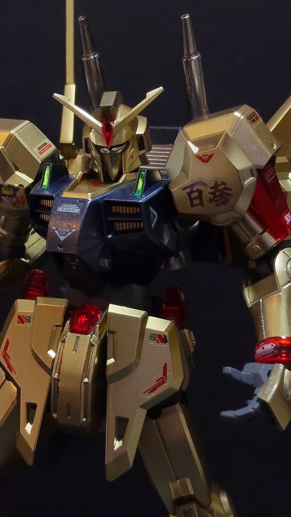 2.&nbsp;&nbsp;&nbsp;&nbsp;＜開発の背景と幻のフラッグシップ＞　ブレックス・フォーラ准将が暗殺された後、クワトロ大尉（シャア・アズナブル）はエゥーゴの次期最高指導者として周囲から強く推される存在となった。この事態を受け、エゥーゴの出資者であるウォン・リーはAE社代表のメラニー・ヒュー・カーバインへ強力に働きかけ、可変第3世代敵MSの登場で力不足が否めなくなった百式にかわり組織の象徴（フラッグシップ）として絶対的な性能を持つ後継MSの準備を急がせた。