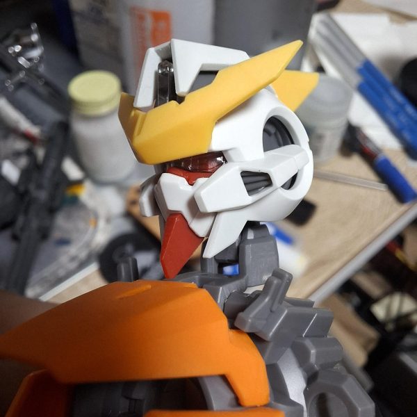 MG キュリオス製作していきます。まずは顔面整形。赤線と矢印のボス切り落として幅詰め。面長のシルエットを目付きの鋭い小顔に強制整形。（5枚目）