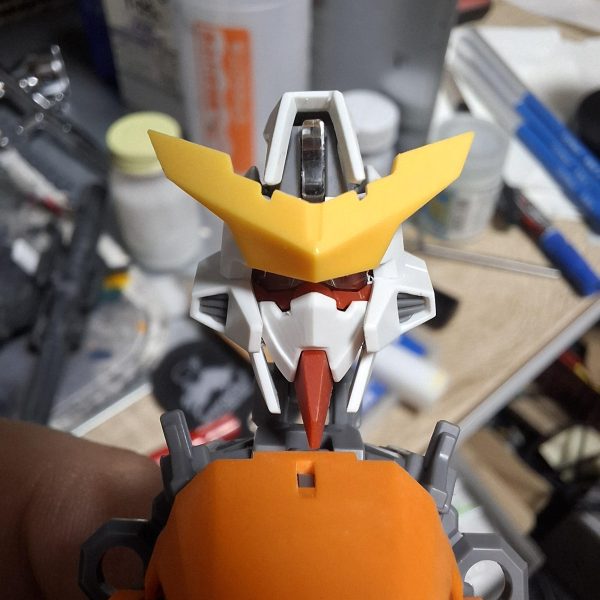MG キュリオス製作していきます。まずは顔面整形。赤線と矢印のボス切り落として幅詰め。面長のシルエットを目付きの鋭い小顔に強制整形。（3枚目）