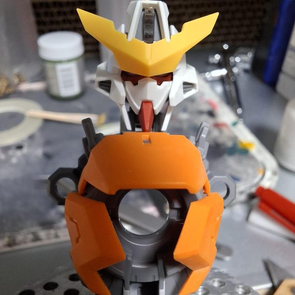 MG キュリオス製作していきます。まずは顔面整形。赤線と矢印のボス切り落として幅詰め。面長のシルエットを目付きの鋭い小顔に強制整形。（4枚目）