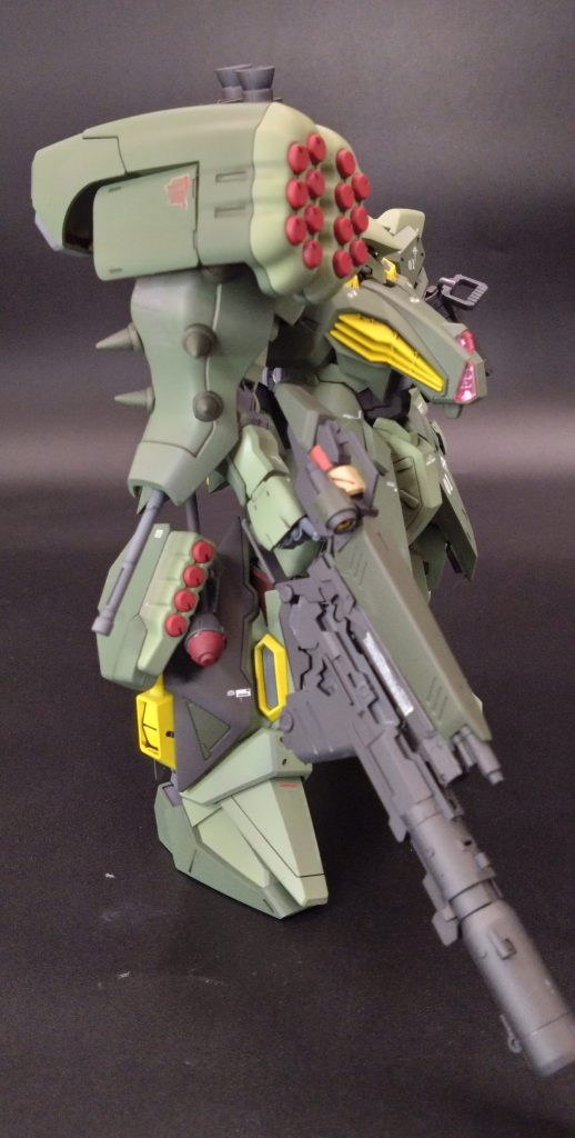 重装特務仕様の武装はそのパイロットによって装備は違い特にその中で代表としてこの画像のチームサイクロプス０１パイロットはジオン系の武装統一してるのが特徴でメッサ―専用ビームライフルにネオジオン時に使用したジャイアントバズを下部に取り付けれっる用に改造され、背部にはMS18Eケンプファーが使用した360ｍｍバズーカ二丁・チェーンマイン・シュツルムファウスト・ハンドグレネード・ビームトマホークを携行し肩部・脚部にはハマーン時代のネオジオンのMSズサの多連装ミサイルも着脱できるよう装備できる。余談だがもう片方のアサマ隊はエゥーゴ出身が多くグリプス戦に使用した武器や背部にはディジェの放熱フィンやZのハイメガランチャーを使用していることが確認している。