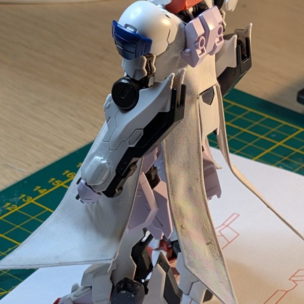 袖なしコート製作のフェーズ1が完了しました！何度も紙で型紙（試作）を作って理想の形を決めてから、布を切り出しています。さらに、ポージングができるようにコートにはワイヤーを仕込みました……！次のステップは、この上にプラ板を追加していく作業です！」（2枚目）