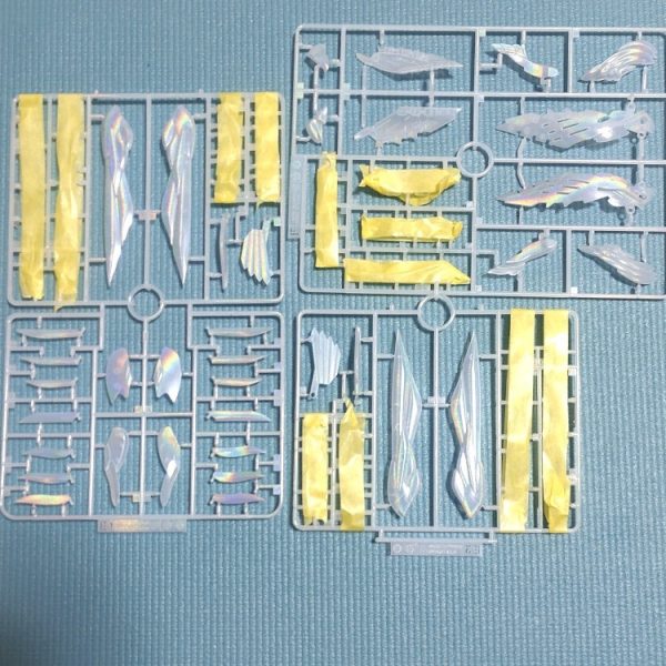 今回はSDを除けば初めて作る機体だし、クリア版ということでウイング以外はそのまま組み立てます。ウイングゼロEWと云えばパール塗装が定番のような気がしていたので、私は気になっていたホログラム塗装をしてみたいと思います。動画をいろいろ見たところ、水性トップコートも使えるようだったので。で。ガンダムマーカー月光蝶ホロシルバーをエアブラシシステムで吹いてみました。画像でも虹色になっている部分があるのが分かりますね。イエローゴールドなどと同様にペン先はすぐ乾いてしまうので、一つのランナーを塗るのに３～４回はペン先を押し付けてインクを出してやる必要があります。また、吹くときは透明なのでちゃんと塗られているのかどうか非常に分かりにくい！目に近づけてまじまじと見てやっと分かるくらいです。とちょっとした苦労はありますが、予想以上にいい感じになりそうです