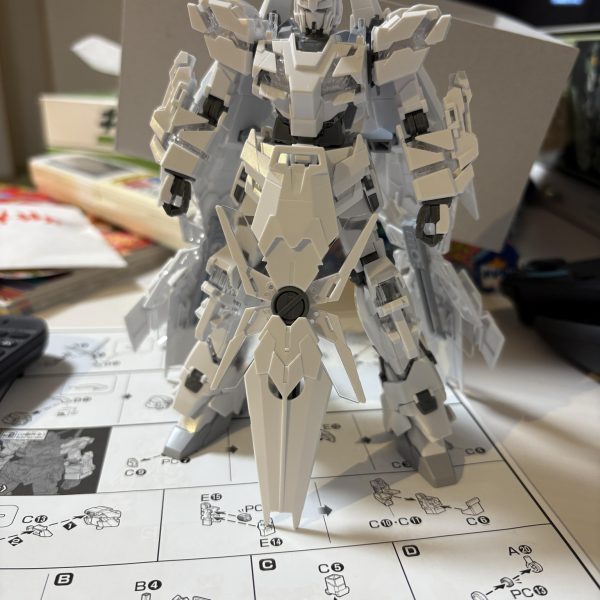 切った貼ったして改造完了最初はフェネクスの形で色だけ変えようかと思いましたが、脳内構想を形にするには改造が必要だったので頑張ってみました！機体のシルエットををマントやドレスをつけたような形を目指しました。バックパックを腰に貼り付け、バックパック取り付け穴は塞ぎました。サーベルは腰に帯刀しています。前垂れに見立てたシールドはマグネットで着いています。増設スラスターのみビルダーズパーツを使っていますが、他は全てペイントモデルのパーツを使っています。今はカラーリングの構想中です。（7枚目）