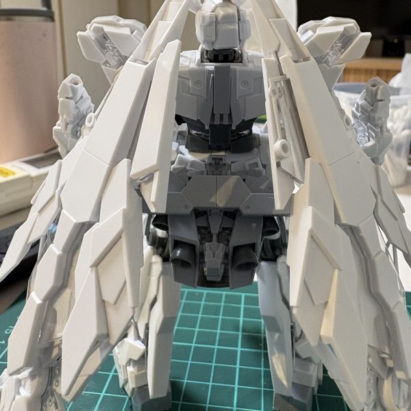 切った貼ったして改造完了最初はフェネクスの形で色だけ変えようかと思いましたが、脳内構想を形にするには改造が必要だったので頑張ってみました！機体のシルエットををマントやドレスをつけたような形を目指しました。バックパックを腰に貼り付け、バックパック取り付け穴は塞ぎました。サーベルは腰に帯刀しています。前垂れに見立てたシールドはマグネットで着いています。増設スラスターのみビルダーズパーツを使っていますが、他は全てペイントモデルのパーツを使っています。今はカラーリングの構想中です。（5枚目）