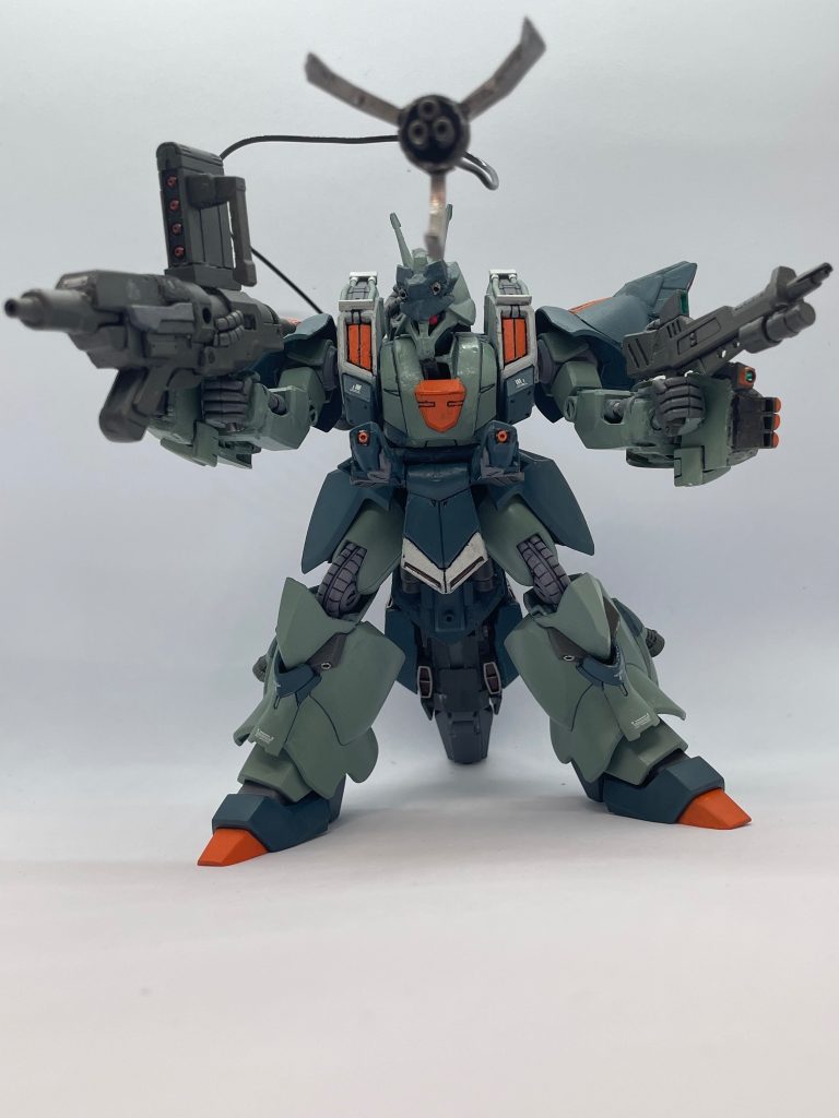 [武装][頭部バルカン砲]ザクⅢ改よりも大口径、頭部に2門装備。[ランチャー・ポッド]両腕に装備している射撃兵装、ガルスJのフィンガーランチャーに相当する武装、そのためマニュピレーターは通常のものに換装されている。[ハイパーエネルギーガン]原型機のエネルギーガンよりも大型化し威力.射程共に強化した武装　ミサイルポッドも使用可能。[ショートビームライフル]リゲルグ用ビームライフルを小型化し、取り回しを強化したもの、グレネードランチャーも使用可能。[肩部ミサイルポッド]原型機と同じ武装。
