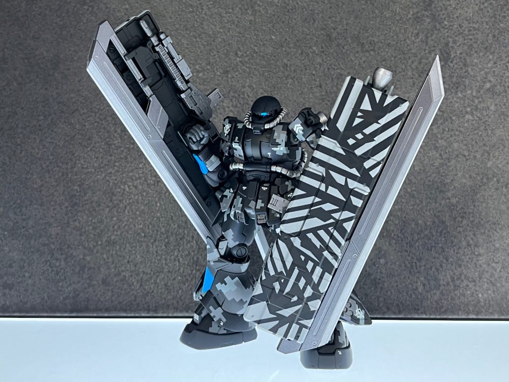 黒とグレイ、オフホワイトの3色からなるドット迷彩が施された高機動型ザク（地上型）。アクセントカラーにブルーの配色を採用している、