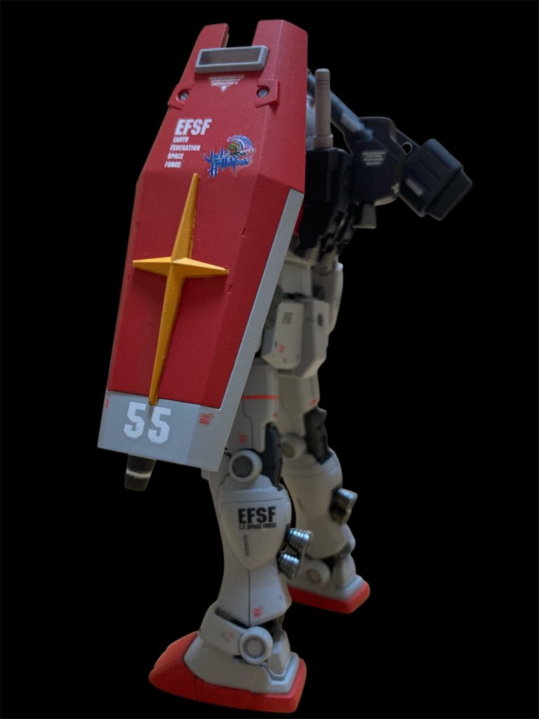 シールドもジム用の飾りを飾ってガンダム用シールドの十時マークを取付け（接着したのでマスキングして塗分け）。シールドにはジャックのパーソナルマークを貼っています。先述の通り、空間突撃仕様の脚部なので脹脛にバーニアがあります。