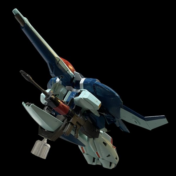 HGリガズィをベースにリガズィカスタムをミキシングして作成して行っています。まずはBWSをスリム化してバックパックとして装備できるようにしました。特徴的なビームアサルトライフルは他のガンプラでは表現が難しい形でしたので、システムウェポン002とデスルターのライフルに加えてNIKKEのプラモデルを使って再現しました。（4枚目）