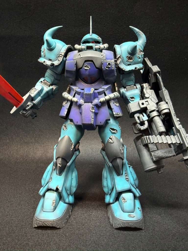 グフカスタム単体で。今回使用したMGグフカスタムは発売が2001年ということでなんともう25年前のキット！ということで、普段は比較的最近のキットばかり作っているのであまりやってこなかった合わせ目消し・段落ちモールド処理と既存モールドの掘り込みを丁寧に行いました。既存モールドの掘り込みを行ったおかげで黒サフ立ち上げで本塗装を行った際、グラデーション塗装を行うことでかなりモールドに黒が残ってくれたので今回はほとんど墨入れを行ってません。足のグラデーション塗装もうまくいっていてお気に入りです。モノアイ・ヘッドと腰のパイプ部分はメタルパーツに置き換えています。