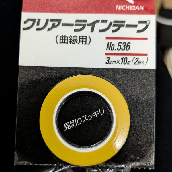 プラモデル製作の醍醐味とも言える、楽しいスジ彫りの時間に取り組みました。今回は、線がよれたりプラスチックがめくれたりしないよう、「とにかく力を入れずに、ゆっくりと何度も彫り進める」ことを一番のこだわりにしています。ペースは非常に遅く、永遠に終わりそうにない感覚にも陥りますが(笑)、この丁寧な反復が最終的な仕上がりの美しさに直結すると信じています。作業工程としては、以下の3ステップを徹底しました。1. ケガキ針:まずはアタリをつけ、ごく浅い溝を作ります。2. ミネシマキサゲ:溝のバリや微細な歪みを整え、次の刃が入りやすくします。3. ラインスクライバーCS 0.15mm:最後に専用ツールで底面が平らな美しいパネルラインを仕上げます。この順序を踏むことで、かなり納得のいくシャープな線が引けました。また、ガイド用として今回の機体からはじめて「ニチバンのクリアラインテープ(曲線用3mm)」を使用してみました。曲面パーツに対しても非常に追従性が高く、テープのフチがクリアに見えるため刃先を合わせやすく、物凄く使いやすいので初心者の方にも強くオススメできるツールです!引き続き、焦らずコツコツと理想のディテールを追求していきます!(5枚目)