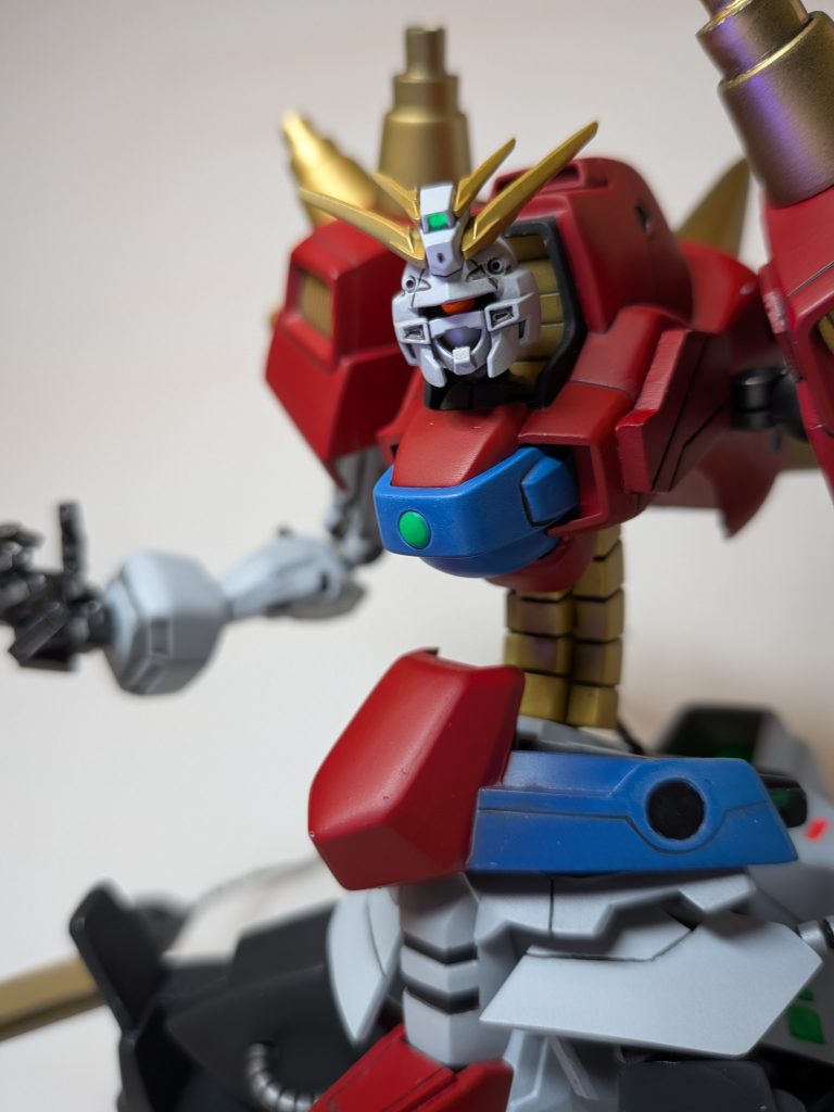 ［頭部がゴッドガンダムの形状であるのは、「自身の敗れたゴッドガンダムを模すことで力を高める」という自己進化の方向性が表面化したためである］頭部はブレイジングガンダムの物を使用。ただ、そのままだと面白くないのでモノアイにすることで悪役感を出しました。